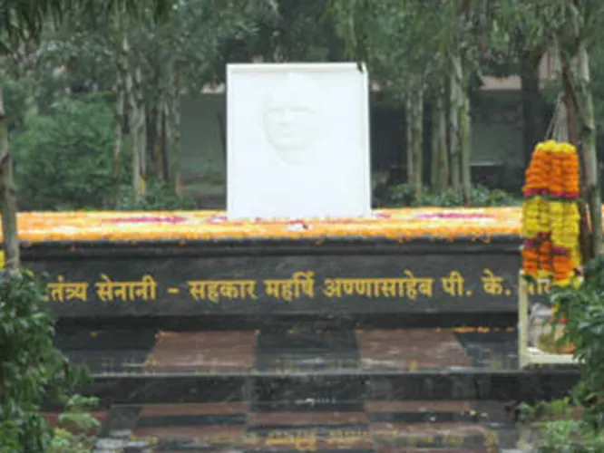 Shakti Sthal memorial: flower tributes in front of a white plaque and an inscribed low wall