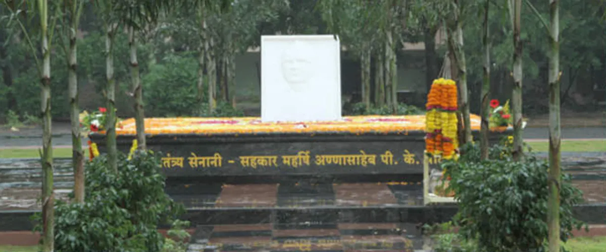 Shakti Sthal, the memorial on the Shahada campus: a floral tribute in front of a white portrait plaque and a low wall with an inscription