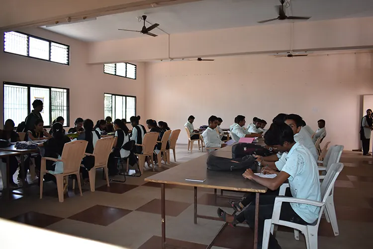 Students seated at long tables in a library reading hall