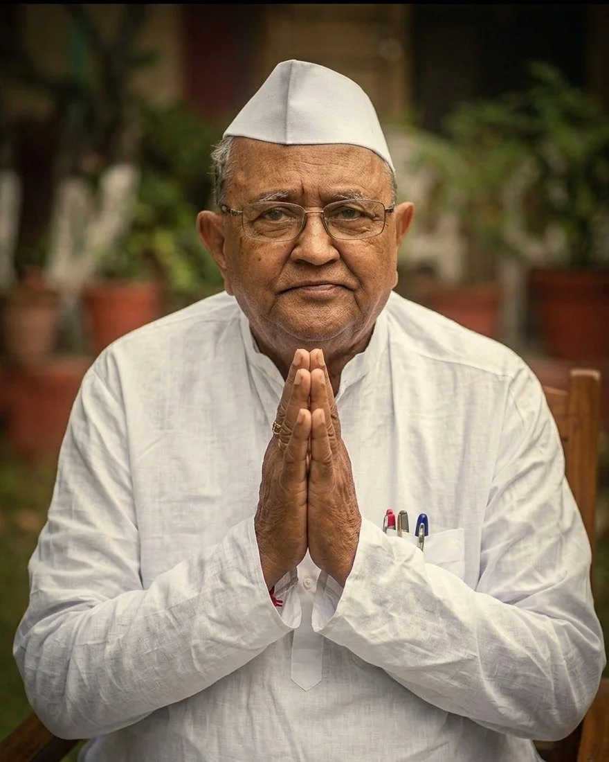 Portrait of Annasaheb P. K. Patil in a white cap and glasses, hands folded in greeting